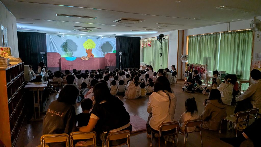 人形劇の舞台と、開演を待つ園児・親子の様子