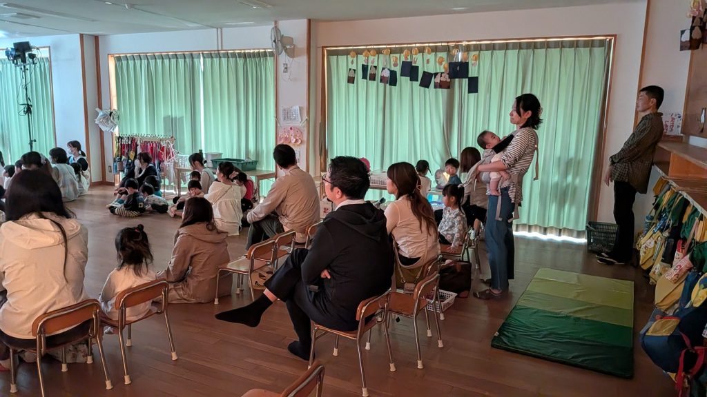 ホール後方で人形劇を鑑賞する親子の様子