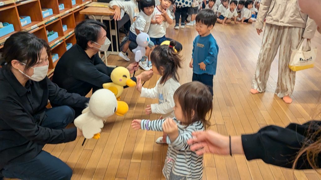 人形たちにさよならのタッチをする子どもたちの様子